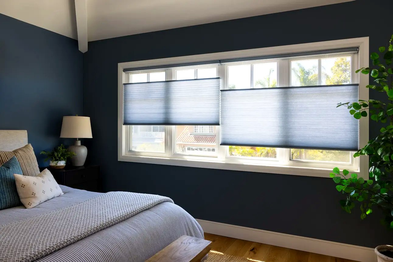 Cellular shades half-lowered in navy bedroom